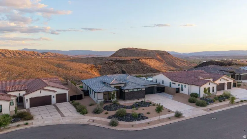 Modern architectural residence showcasing clean geometric lines, multiple roof planes with solar panel integration, and expansive glazing