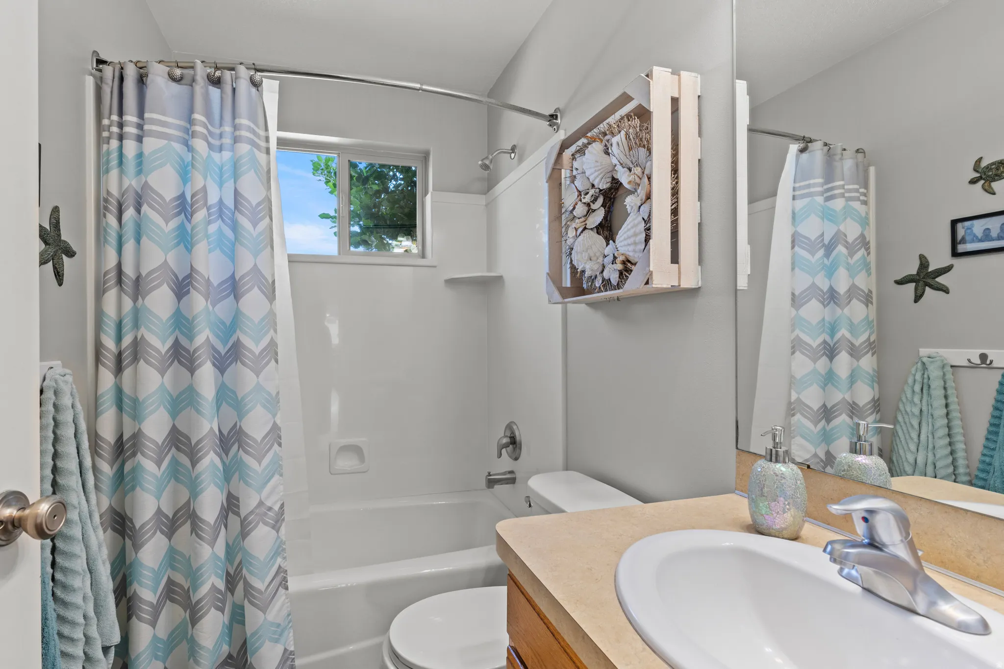 Bathroom featuring a wood-finish vanity with an undermount sink, chrome faucet, and ample counter space