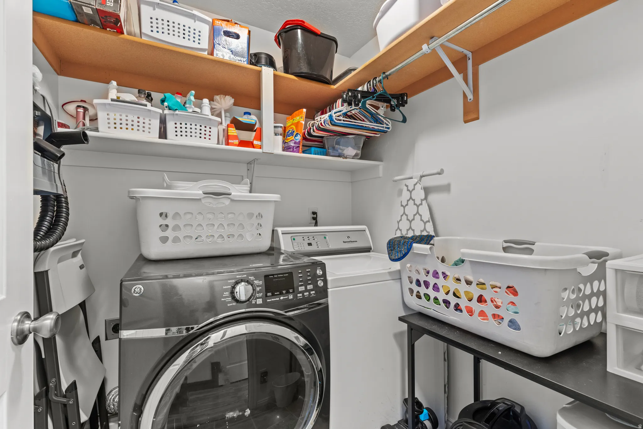 Built-in shelving, white walls, and a light wood-finish shelf with hanging rod