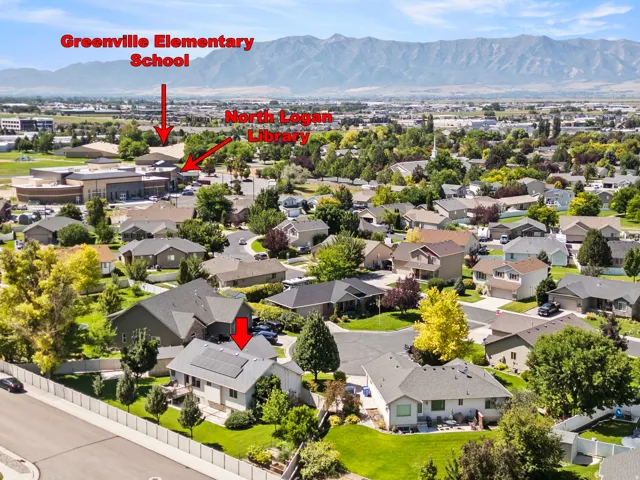 Aerial view of a residential neighborhood featuring tree-lined streets, mature landscaping throughout the community, and proximity to Greenville Elementary School and nearby commercial corridors