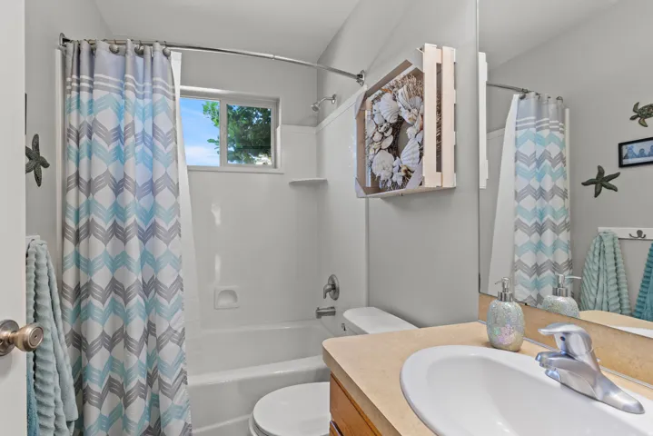 Bathroom featuring a wood-finish vanity with an undermount sink, chrome faucet, and ample counter space