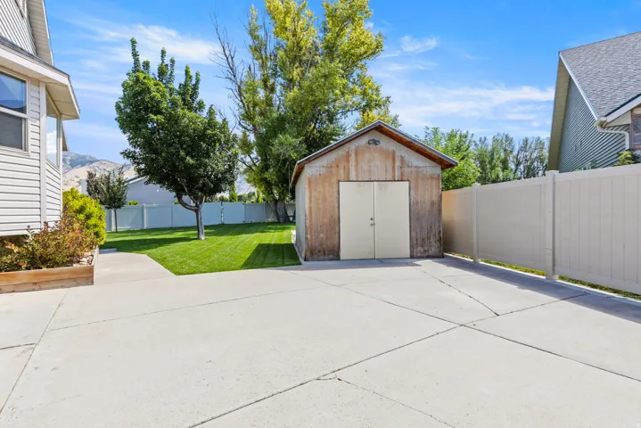 Expansive concrete pad with mature landscaping, including established trees and manicured lawn
