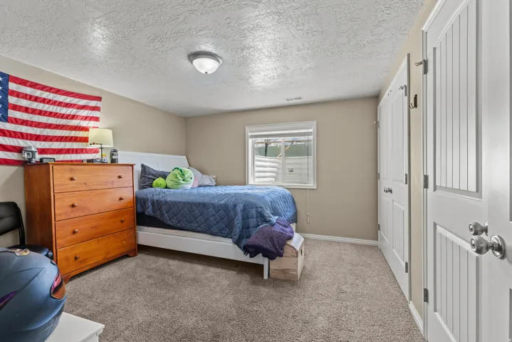 Recessed window with horizontal blinds, neutral wall paint, and grey carpet flooring