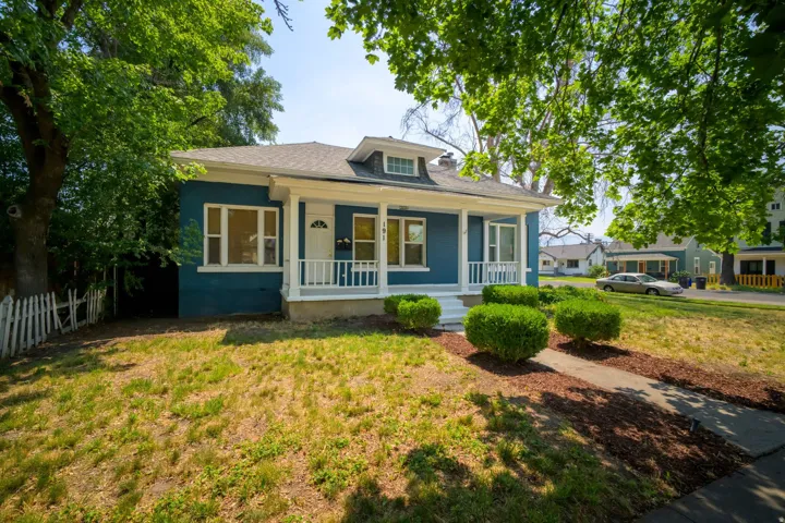 Blue exterior with white trim, covered front porch, and dormer window