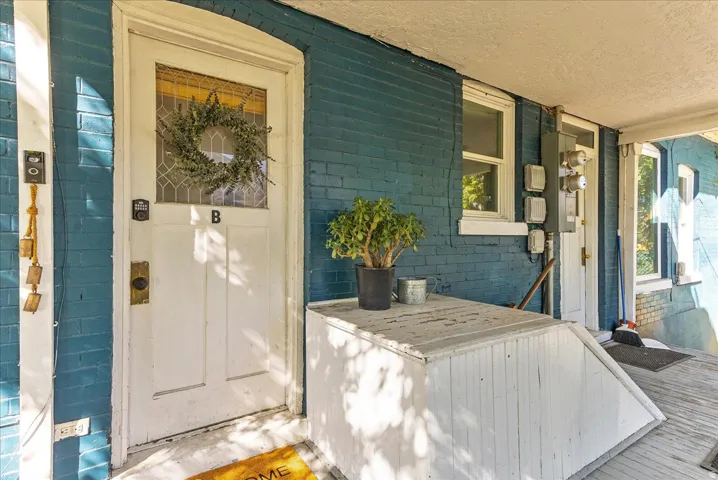 Blue brick exterior with a white entry door, framed by white trim