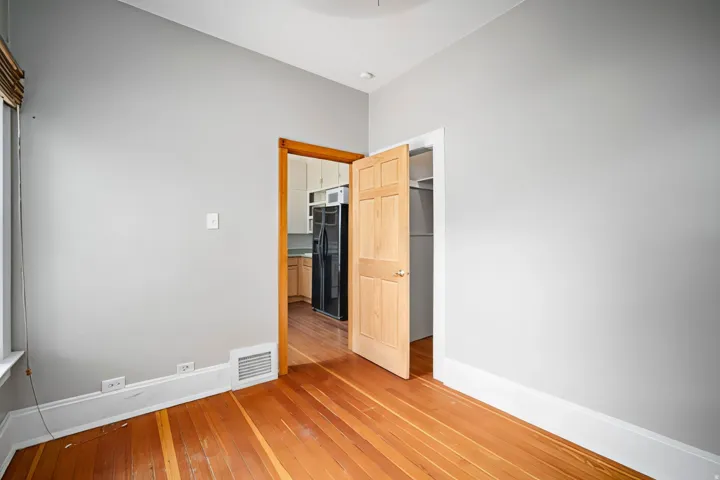 Wood-finish flooring, light grey wall paint, and white trim