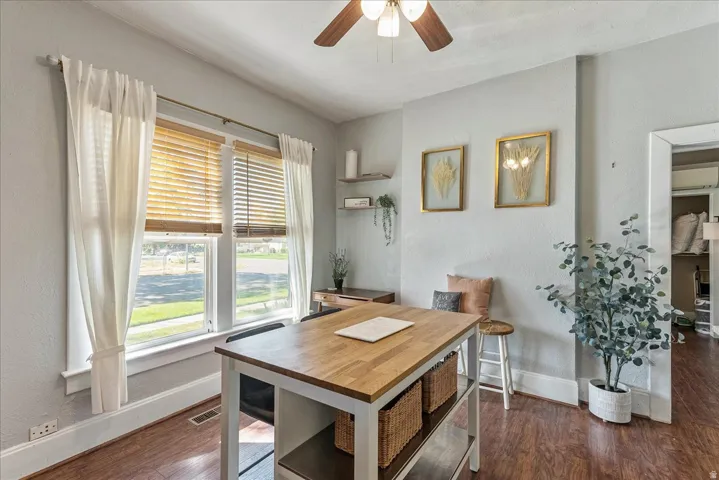 Wood-finish flooring throughout, with a ceiling fan featuring a light fixture