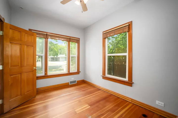 Hardwood flooring, wood-finish door, wood-finish window trim, multiple windows, ceiling fan with light fixture