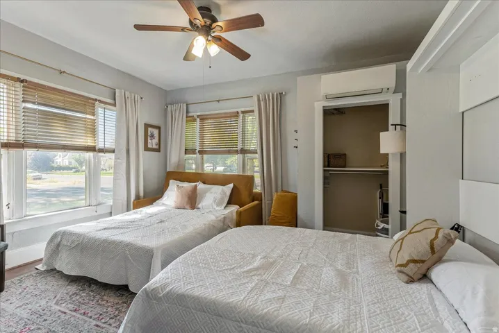 Ceiling fan with integrated lighting, wood-finish blinds, open closet with shelving, and hard-surface flooring