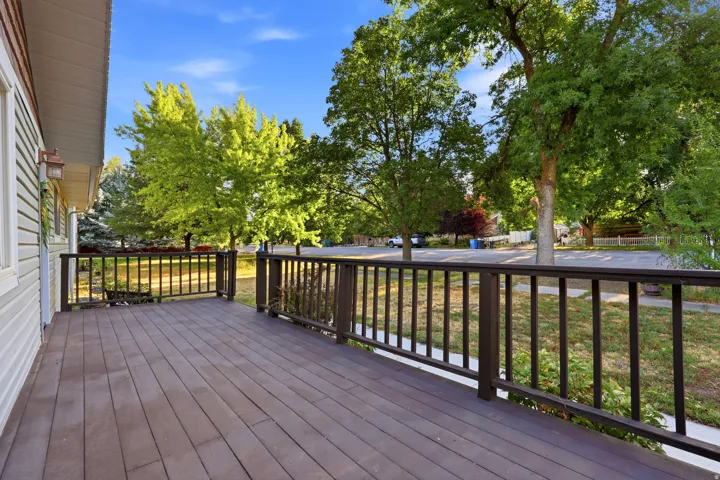 Expansive outdoor deck with composite decking, dark wood railings, and an exterior wall lantern