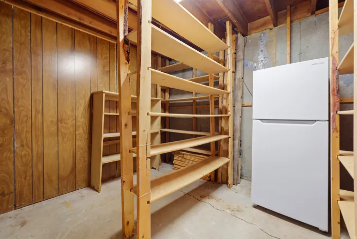 Built-in wood shelving units, wood-finish wall paneling, and a concrete floor