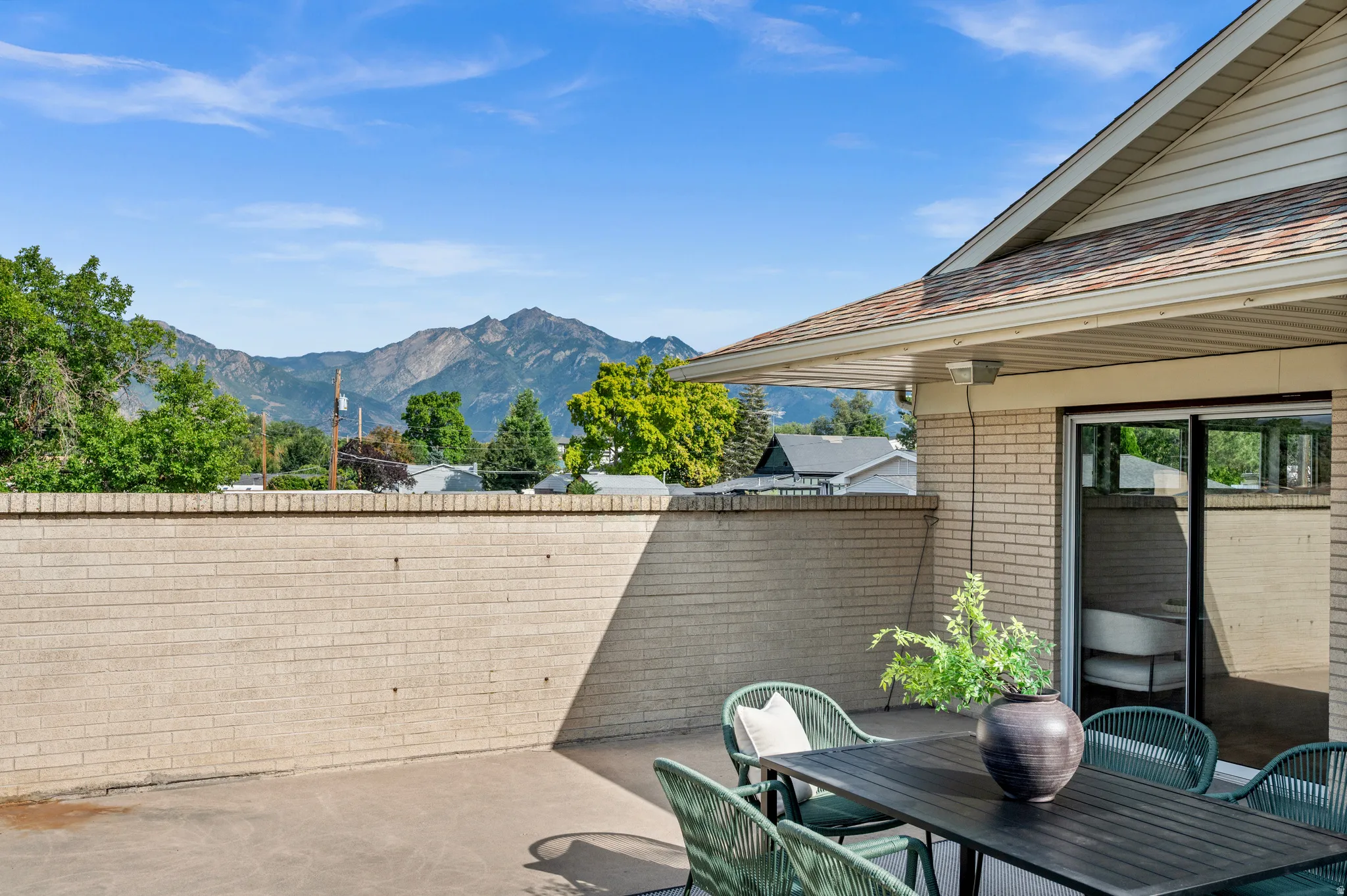 Rooftop deck with composite decking, dining table setup, and mountain backdrop