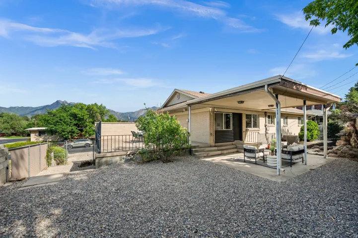 Spacious gravel courtyard with mature landscaping and mountain backdrop