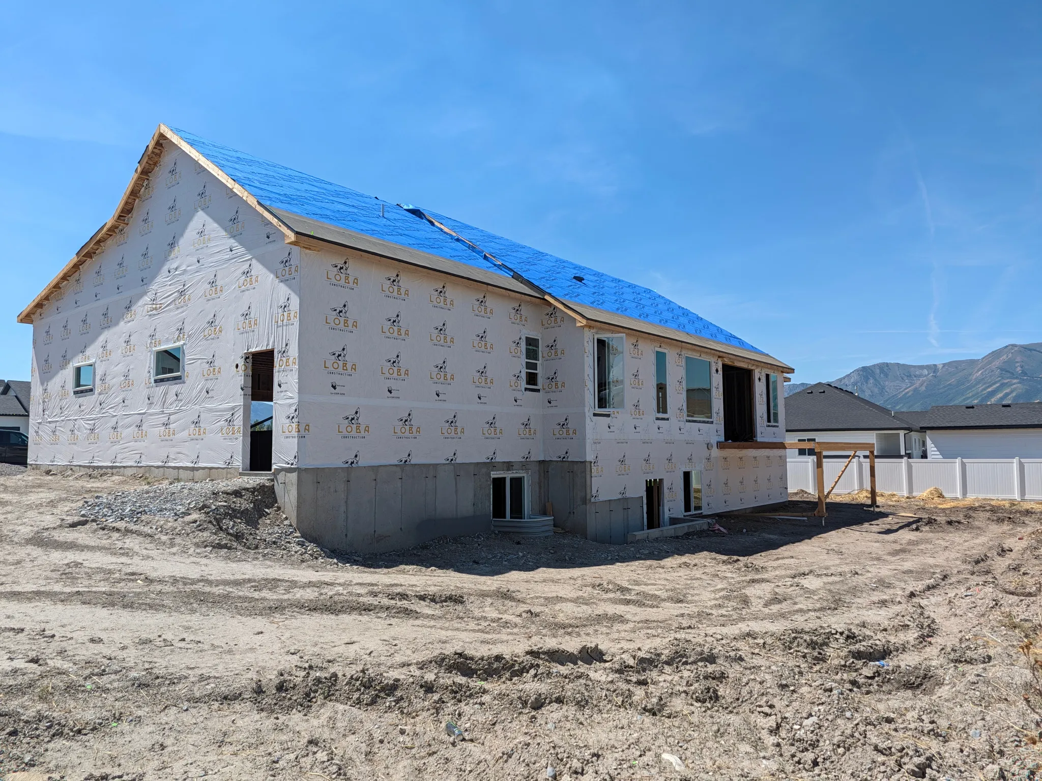 New construction property featuring a full foundation, multiple window openings, and a partially framed deck