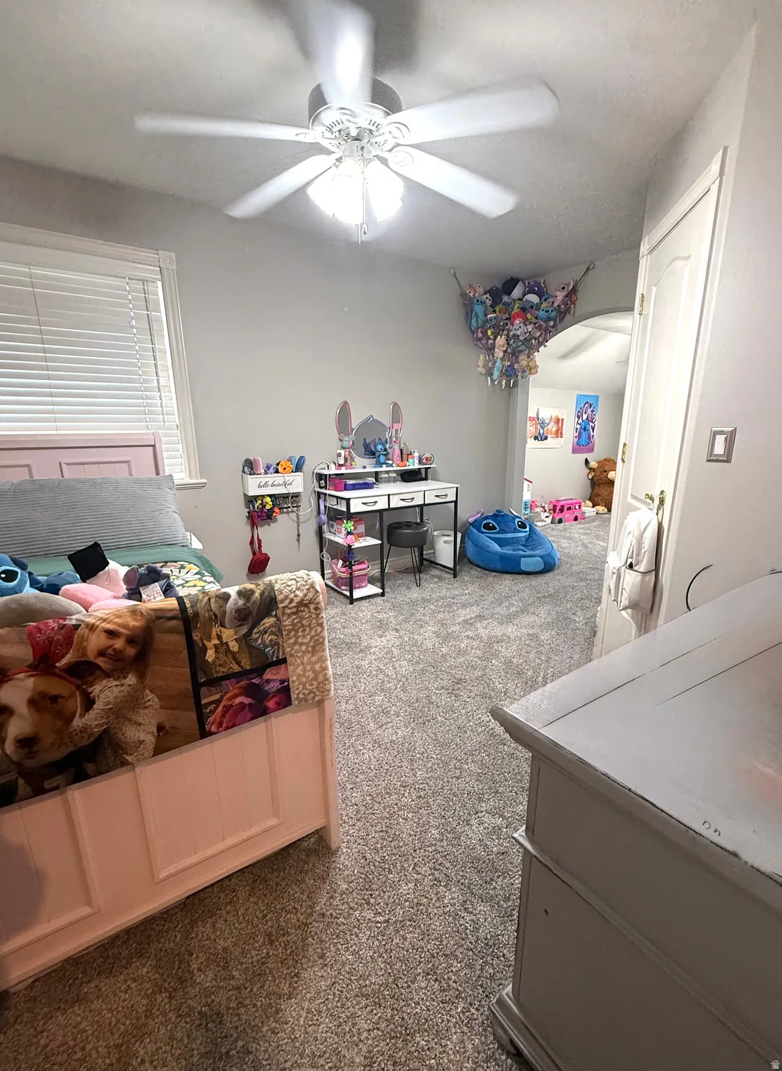 Wall-to-wall carpeting throughout, ceiling fan with integrated lighting, and window with horizontal blinds