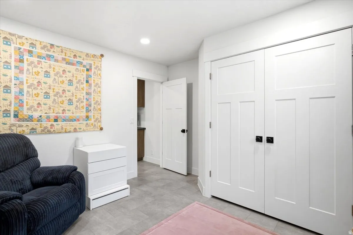 Spacious secondary bedroom featuring neutral finishes, plush carpeting, ample closet storage with dual double-door units, and a three-drawer dresser