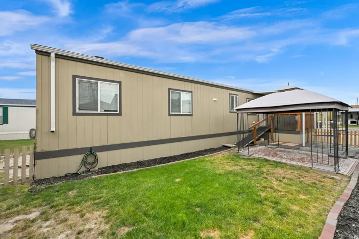 Manufactured home with panel siding, multiple windows, and a covered Gazebo
