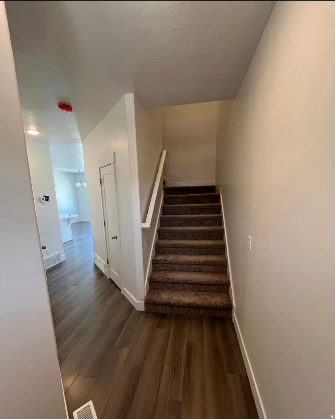 Wood-finish flooring with a carpeted staircase