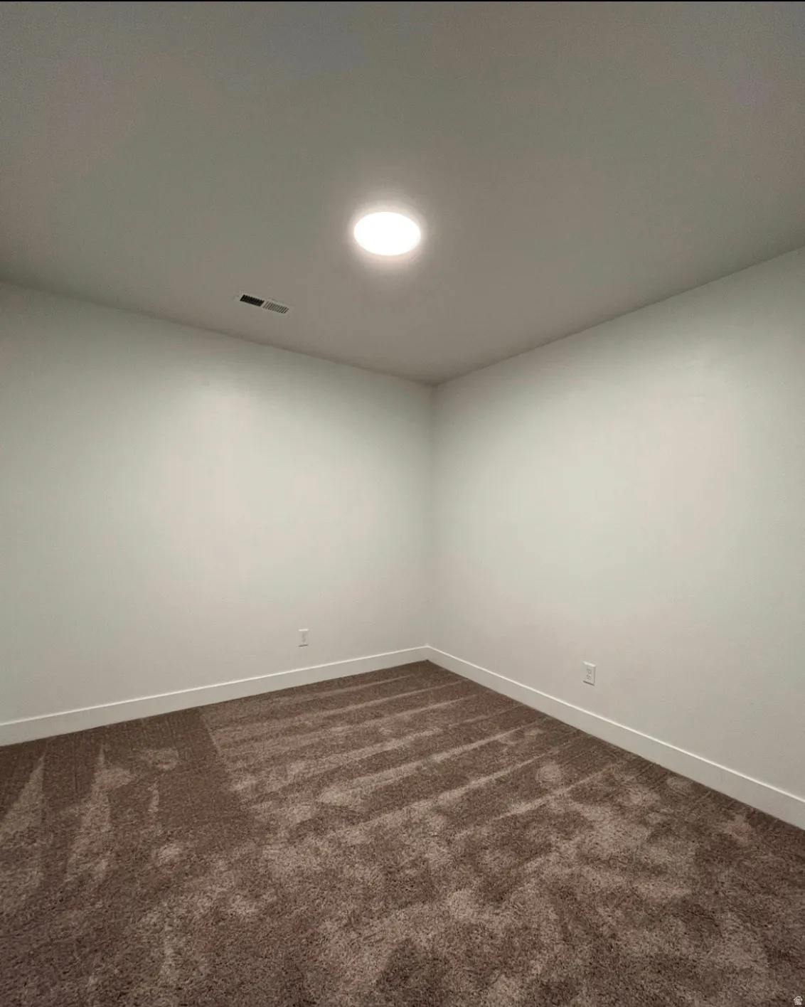 Recessed ceiling lighting, neutral tone carpeting, white walls, and white trim