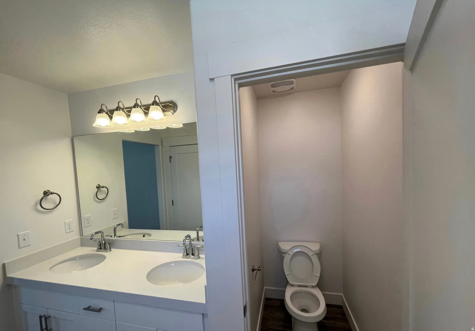 Dual vanity with undermount sinks, single-handle faucets, and a large mirror