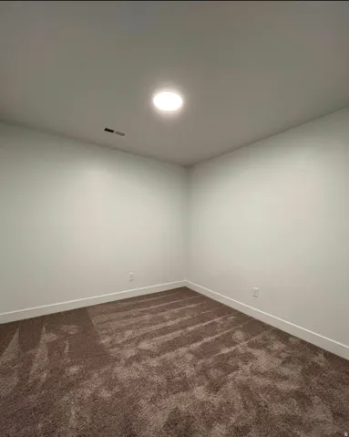 Recessed ceiling lighting, neutral tone carpeting, white walls, and white trim