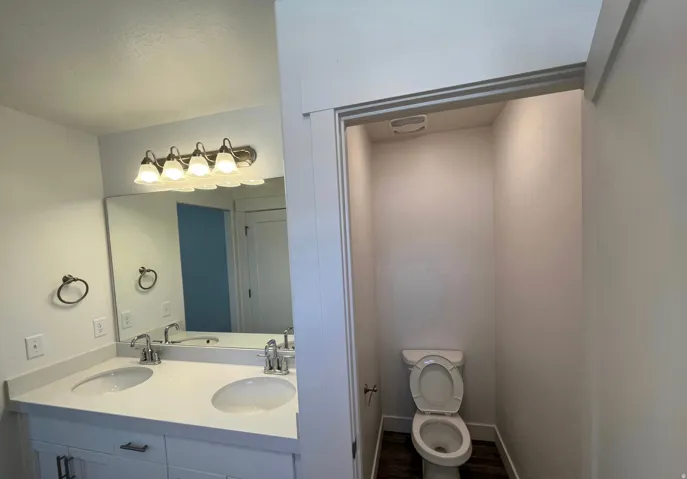 Dual vanity with undermount sinks, single-handle faucets, and a large mirror