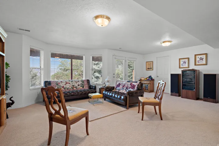 Bay window with multiple glass panes, carpet flooring, recessed lighting, white walls, and a white door with glass panels