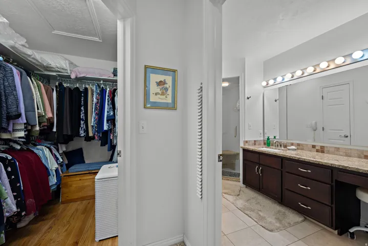 Walk-in closet with wood-finish flooring and built-in shelving