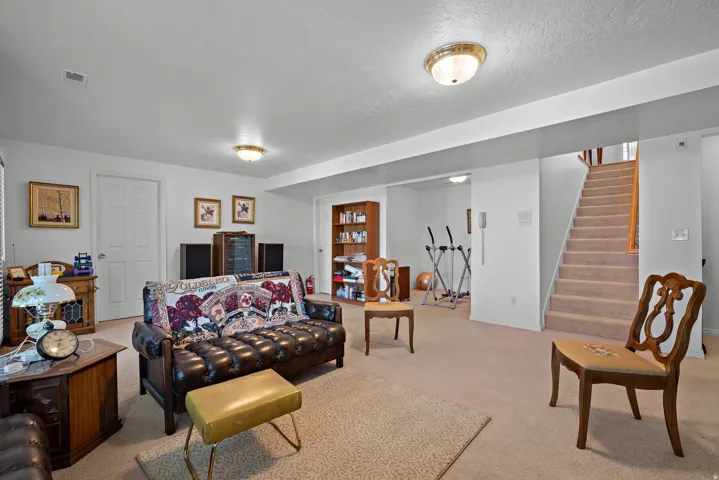 Carpeted flooring, recessed ceiling lighting, and a built-in staircase