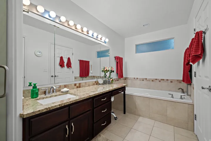 Elongated vanity with a single undermount sink, granite countertop, and dark wood-finish cabinetry
