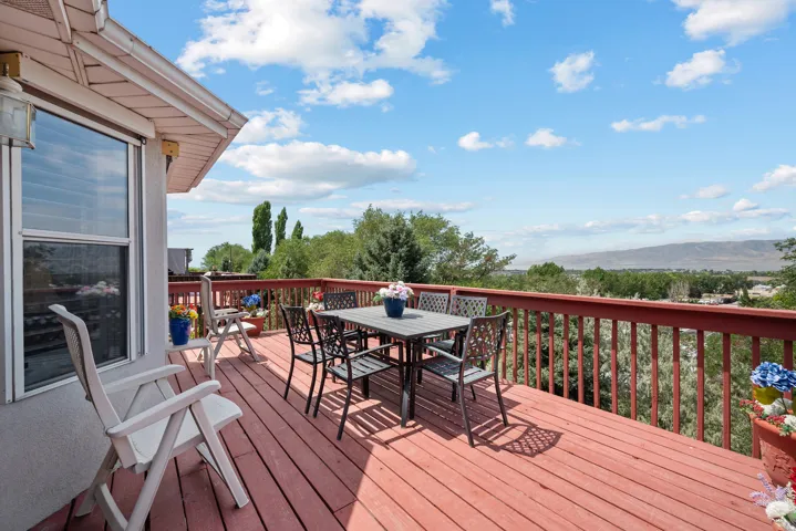 Expansive elevated wood-finish deck with a red-stained surface and matching railings