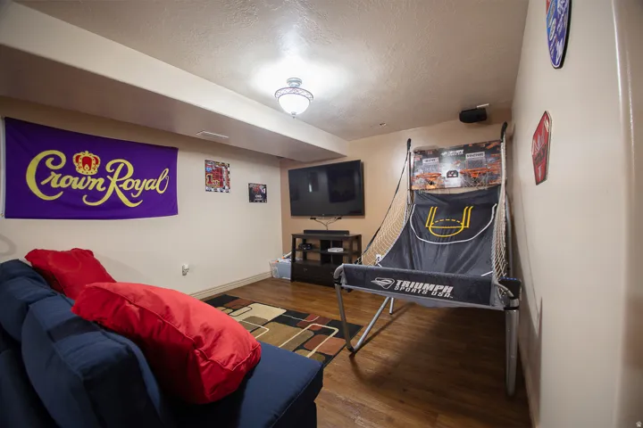 Recessed lighting with a central ceiling fixture, wood-finish flooring, and light-toned wall paint