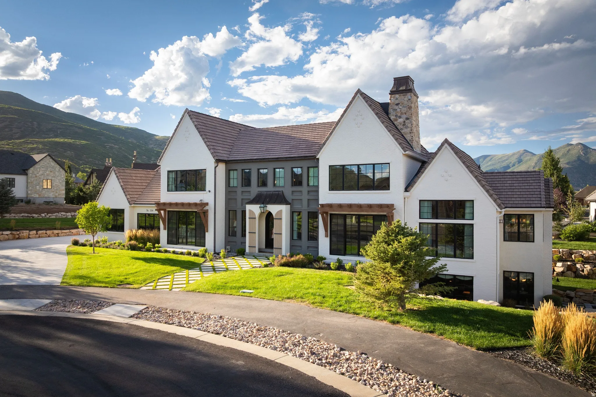 Modern farmhouse residence featuring a striking white exterior with charcoal-accented trim and multiple gabled rooflines