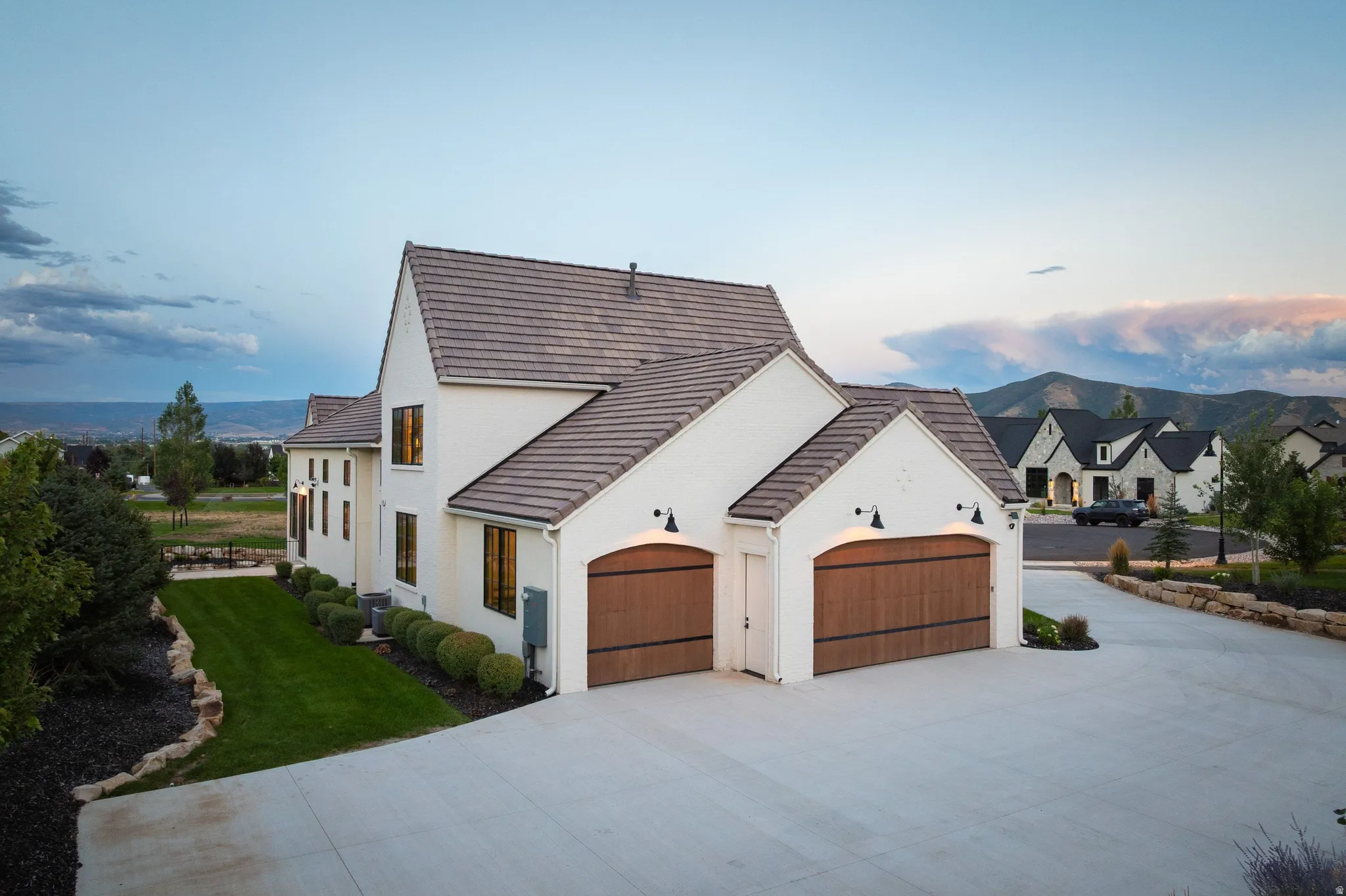 Stucco exterior with a tiled roof and wood-finish garage doors