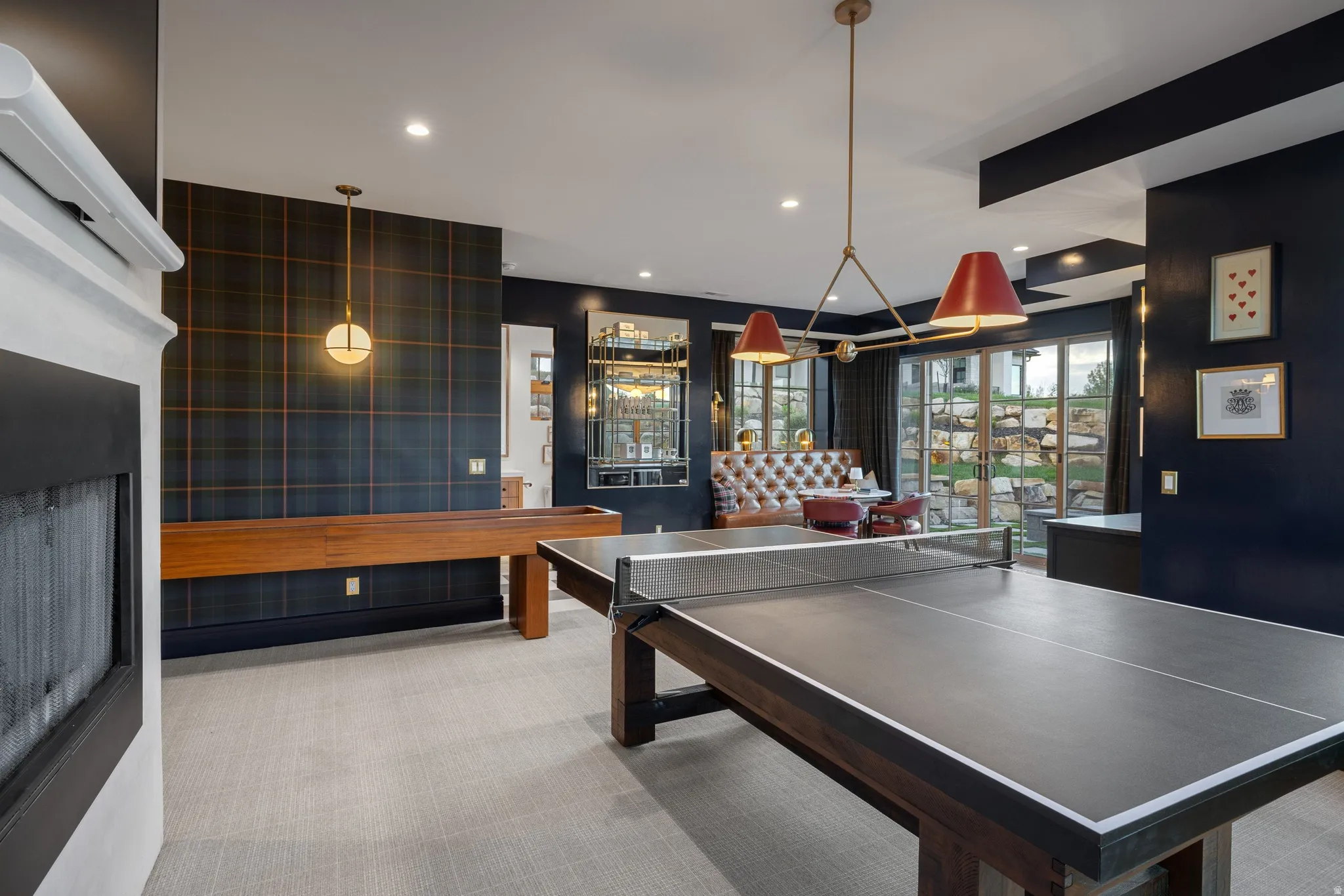 Built-in fireplace, patterned accent wall, recessed lighting, and sliding glass doors to outdoor area