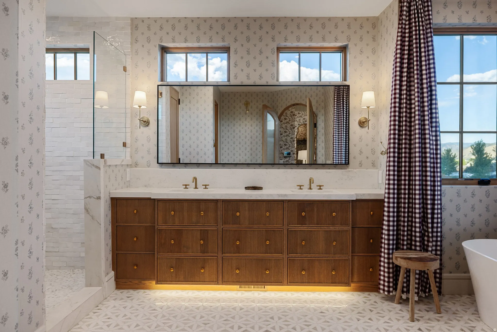 Dual vanity with wood-finish cabinetry, under-cabinet lighting, and integrated sinks