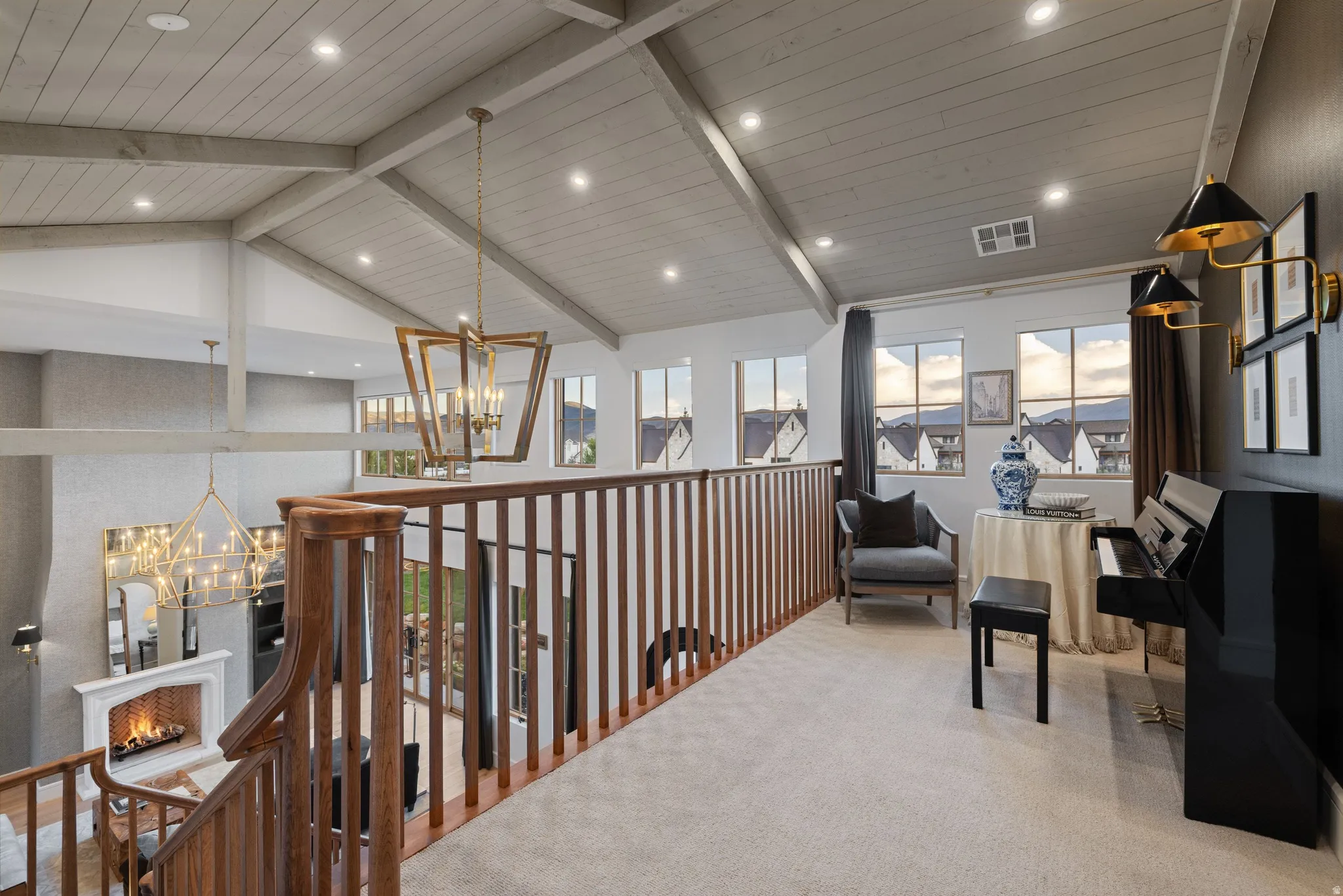 Vaulted shiplap ceiling with exposed beams, wood spindle railing, recessed lighting, and multiple windows