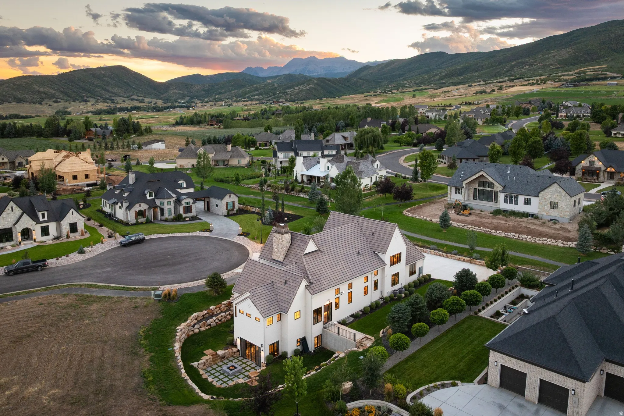 Striking two-story residence with cream exterior and pitched roofline set on expansive grounds