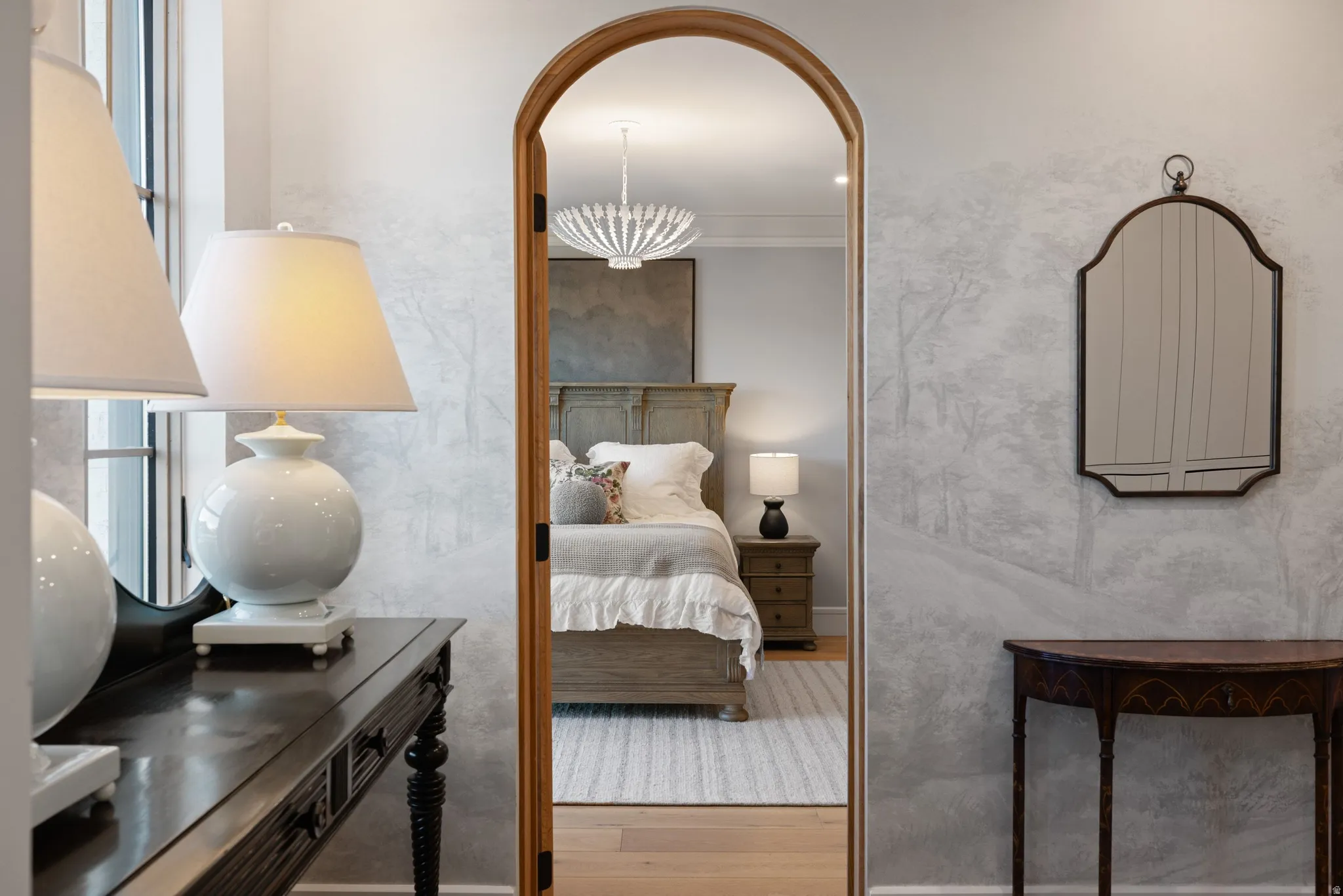 Arched doorway opening, wood-finish flooring, and decorative wall treatment