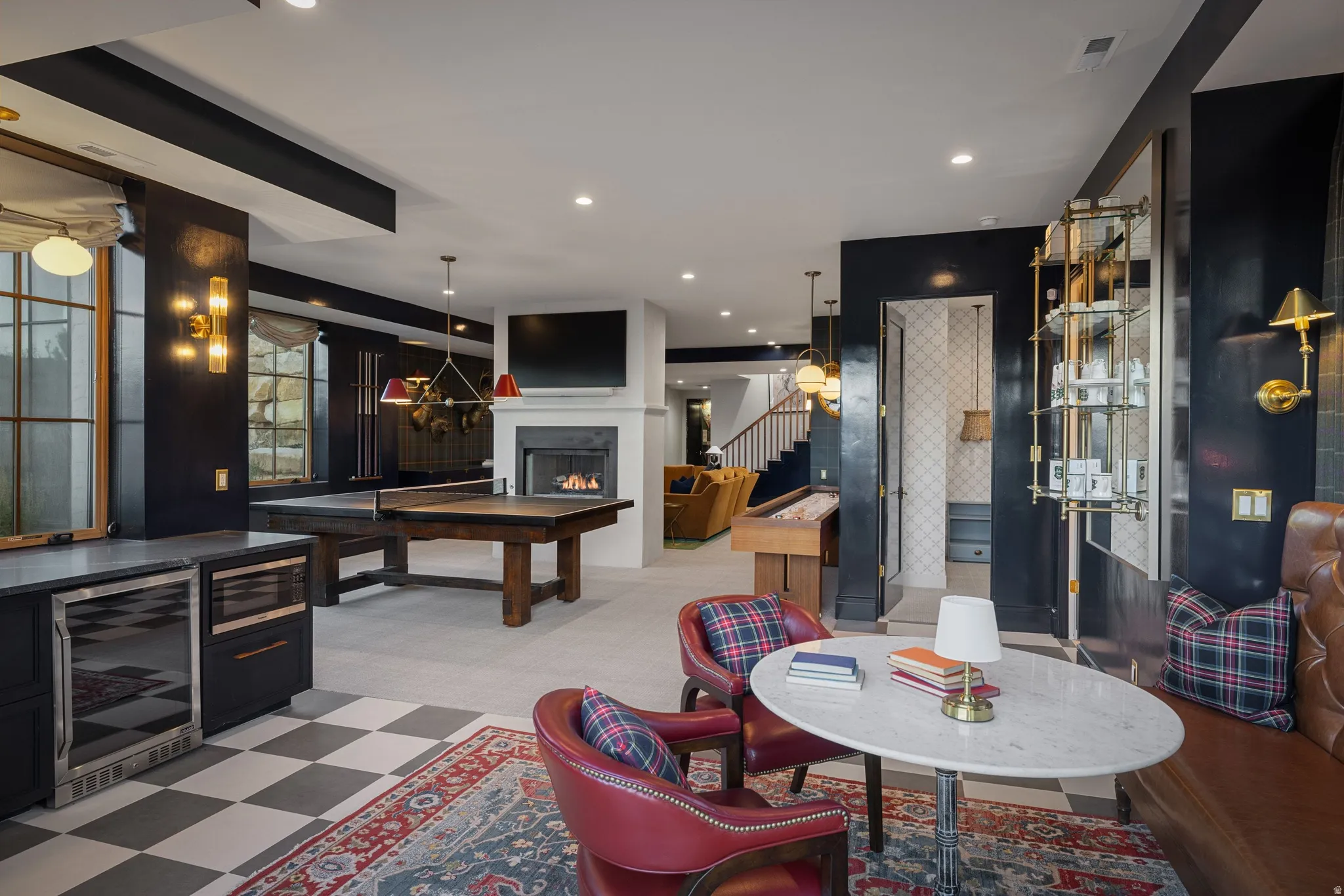 Sophisticated recreation space featuring a wood-finish pool table, built-in bar cabinetry with integrated beverage cooler, fireplace with surround shelving, checkered tile flooring, and recessed ceiling lighting