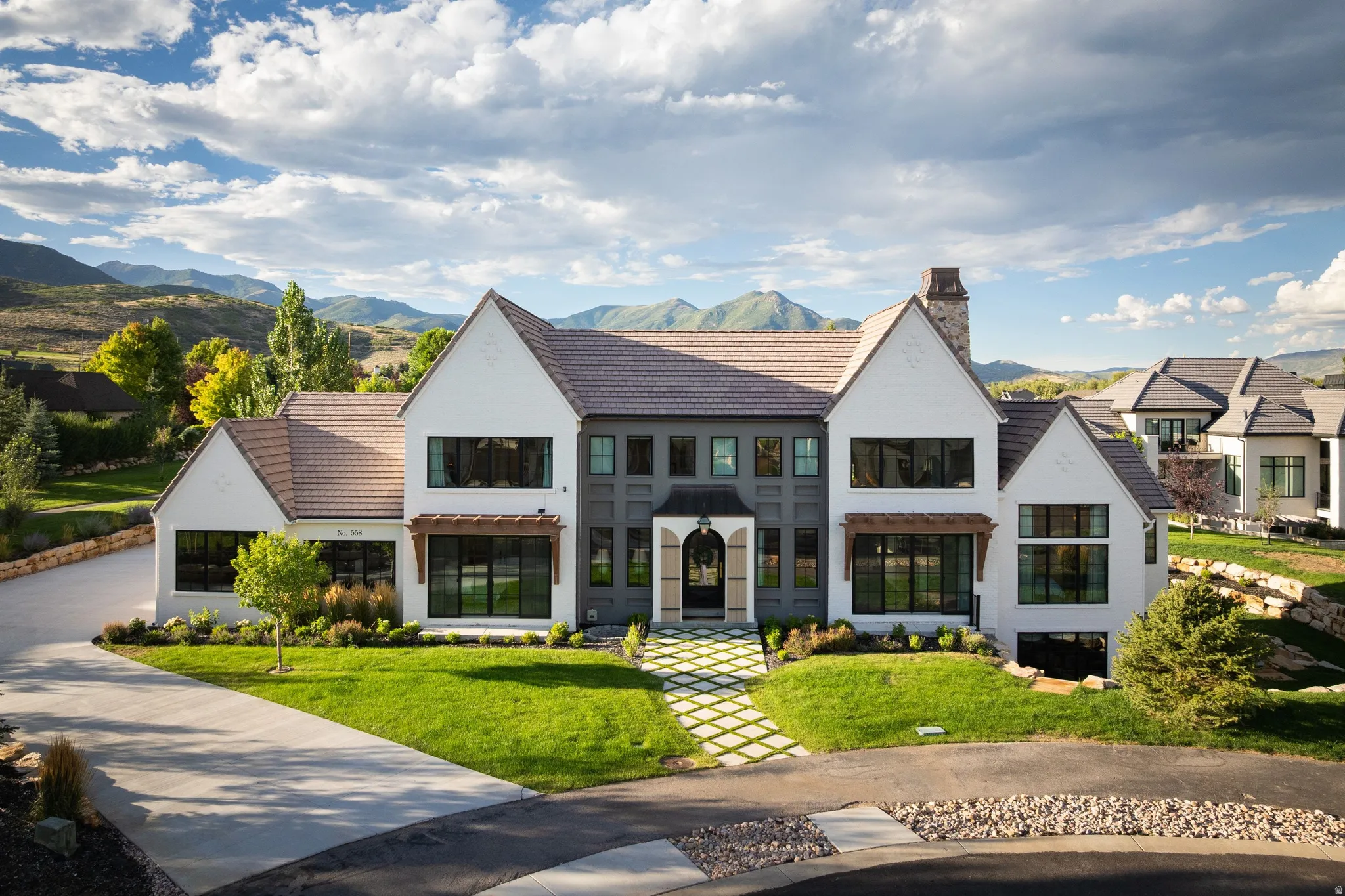Modern farmhouse residence showcasing a striking white exterior with dark roof and multiple gabled peaks