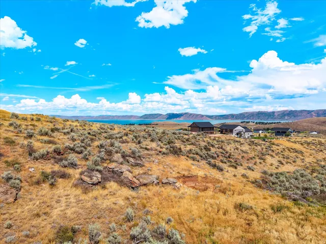 Expansive sagebrush-dotted landscape with rolling terrain and scattered rock outcroppings