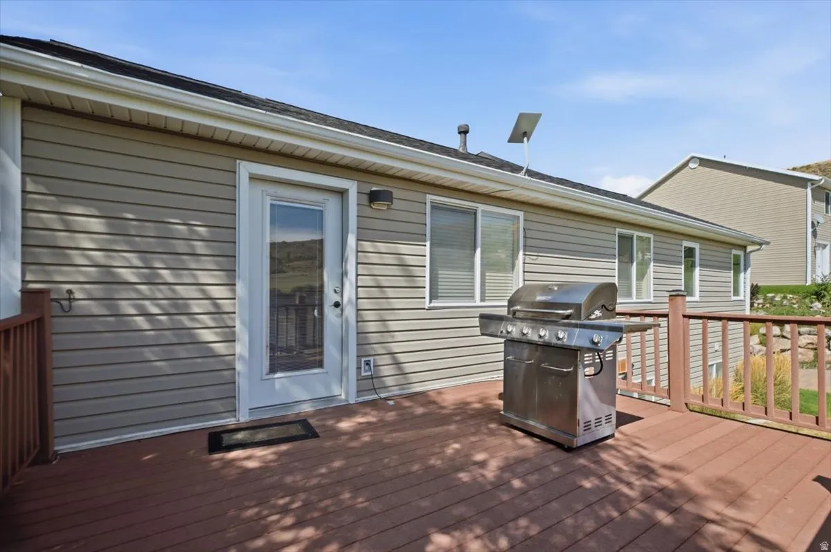 Spacious outdoor deck with composite decking, wood railings, and direct access through a glass-paneled door