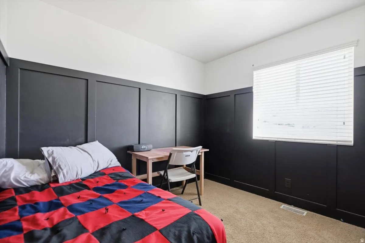 Board and batten wall detailing, neutral carpeting, and a window with blinds