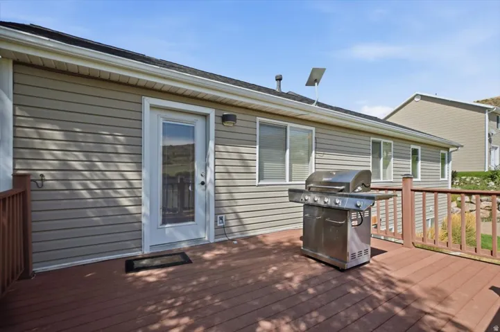 Spacious outdoor deck with composite decking, wood railings, and direct access through a glass-paneled door