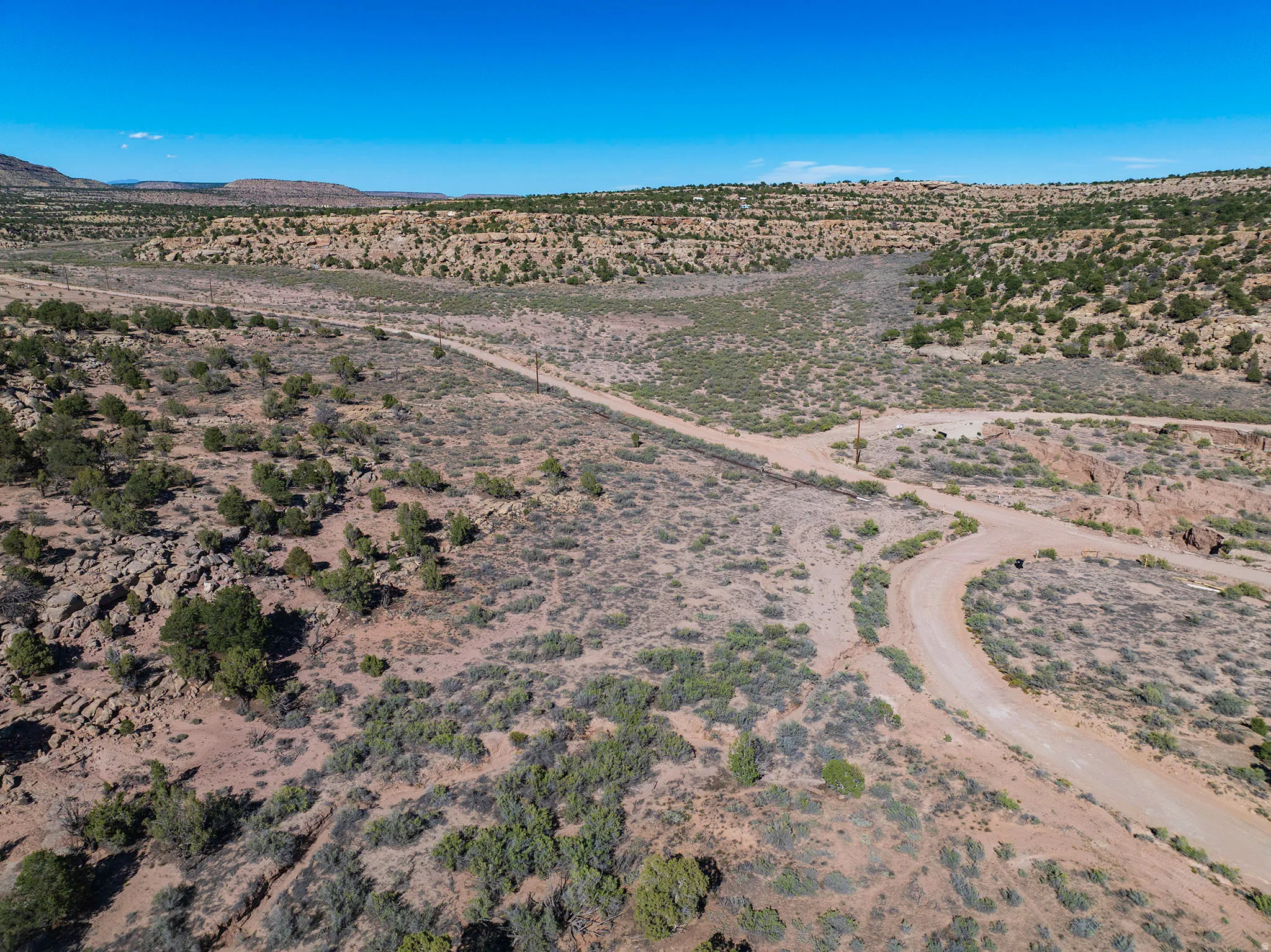 Expansive desert landscape with natural vegetation and unpaved roads