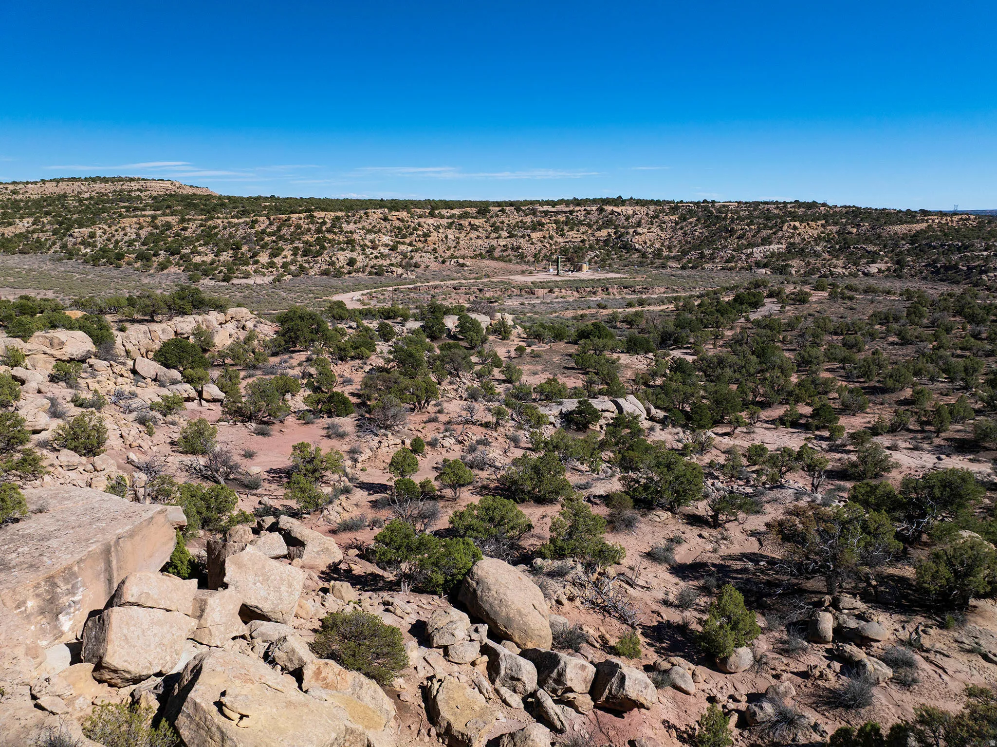 Expansive desert landscape featuring scattered rock formations and varied scrub brush