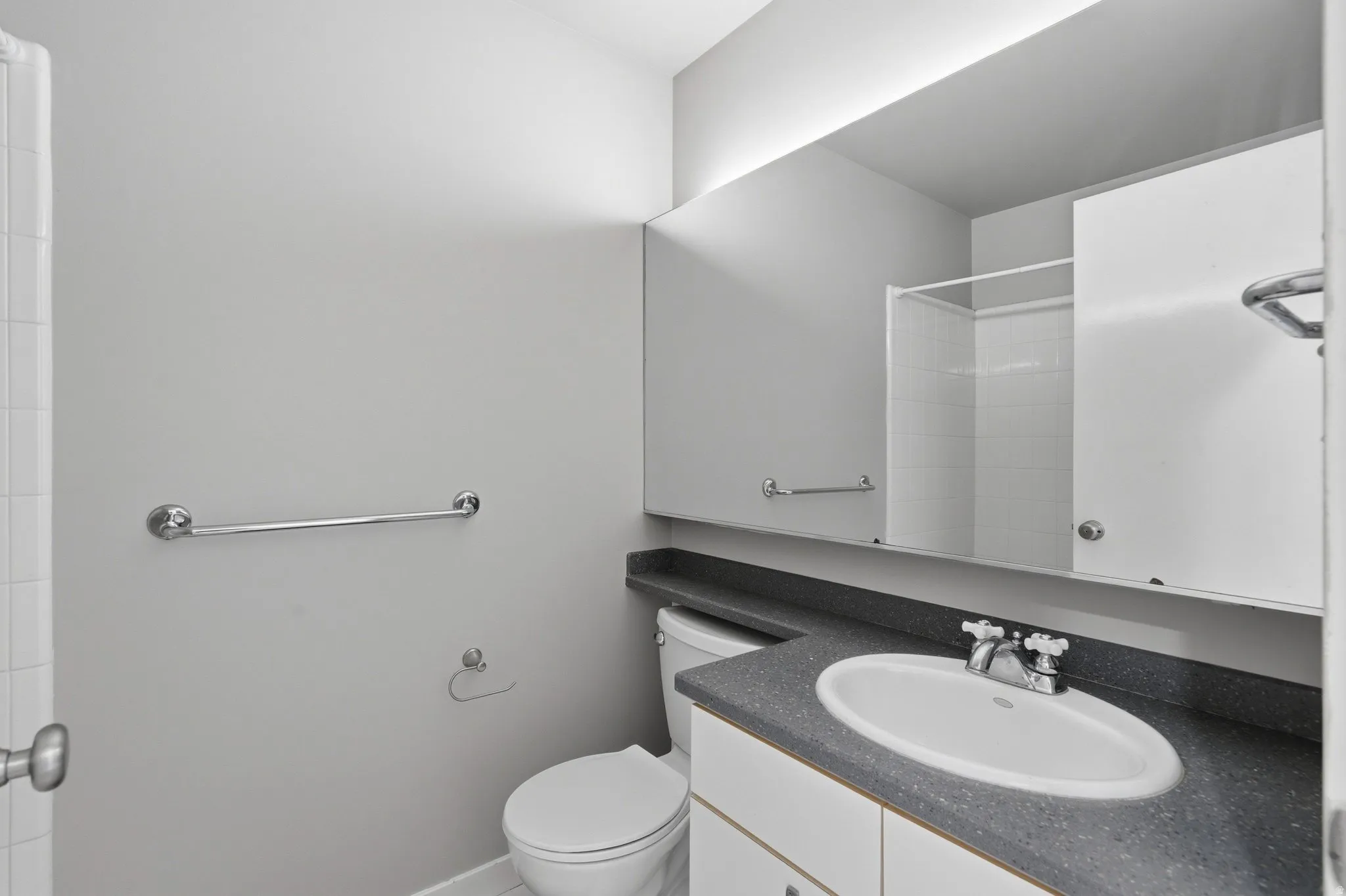 Vanity with an integrated white sink and dark speckled countertop