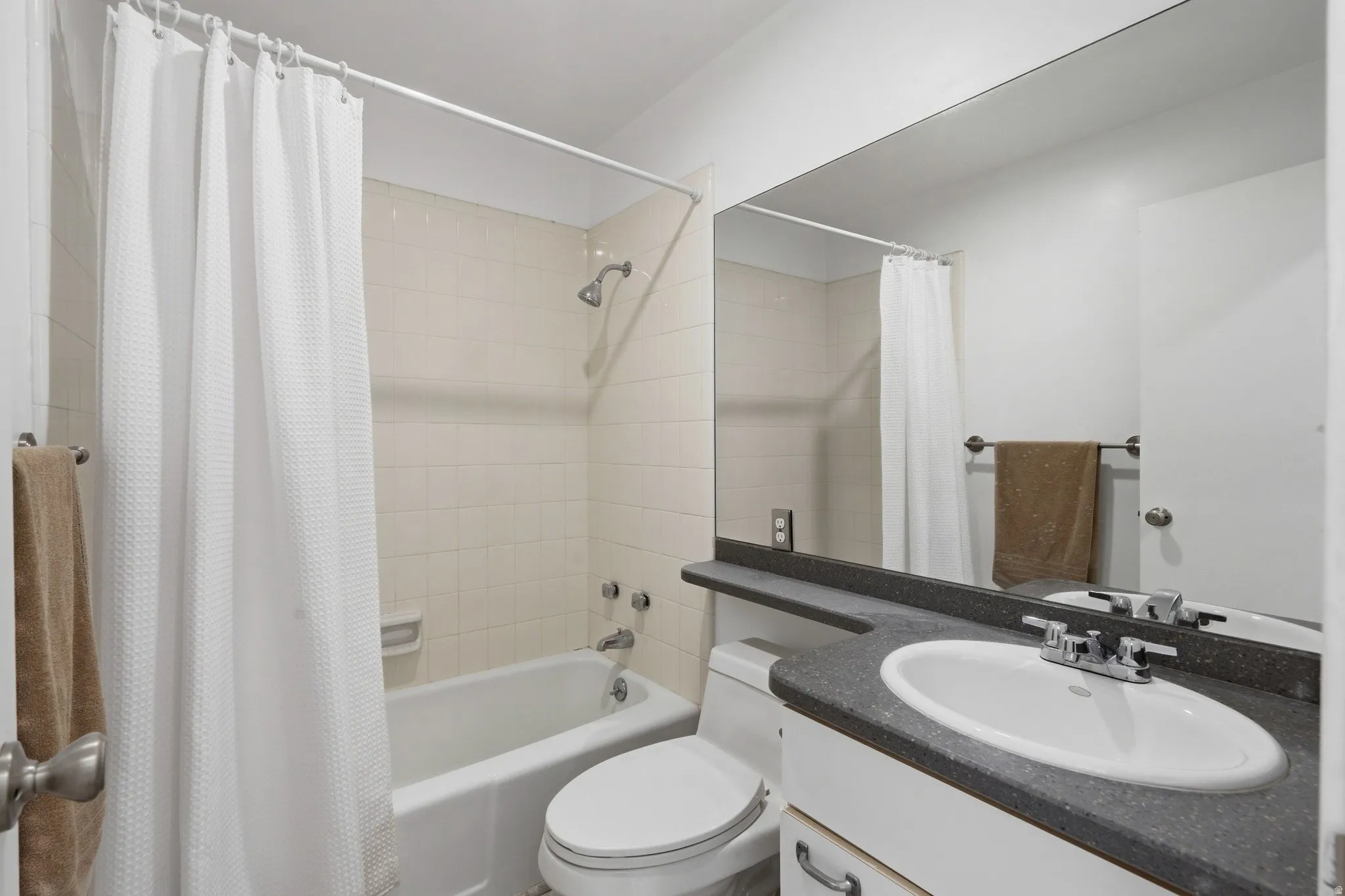 Vanity with integrated sink, chrome faucet, and dark countertop