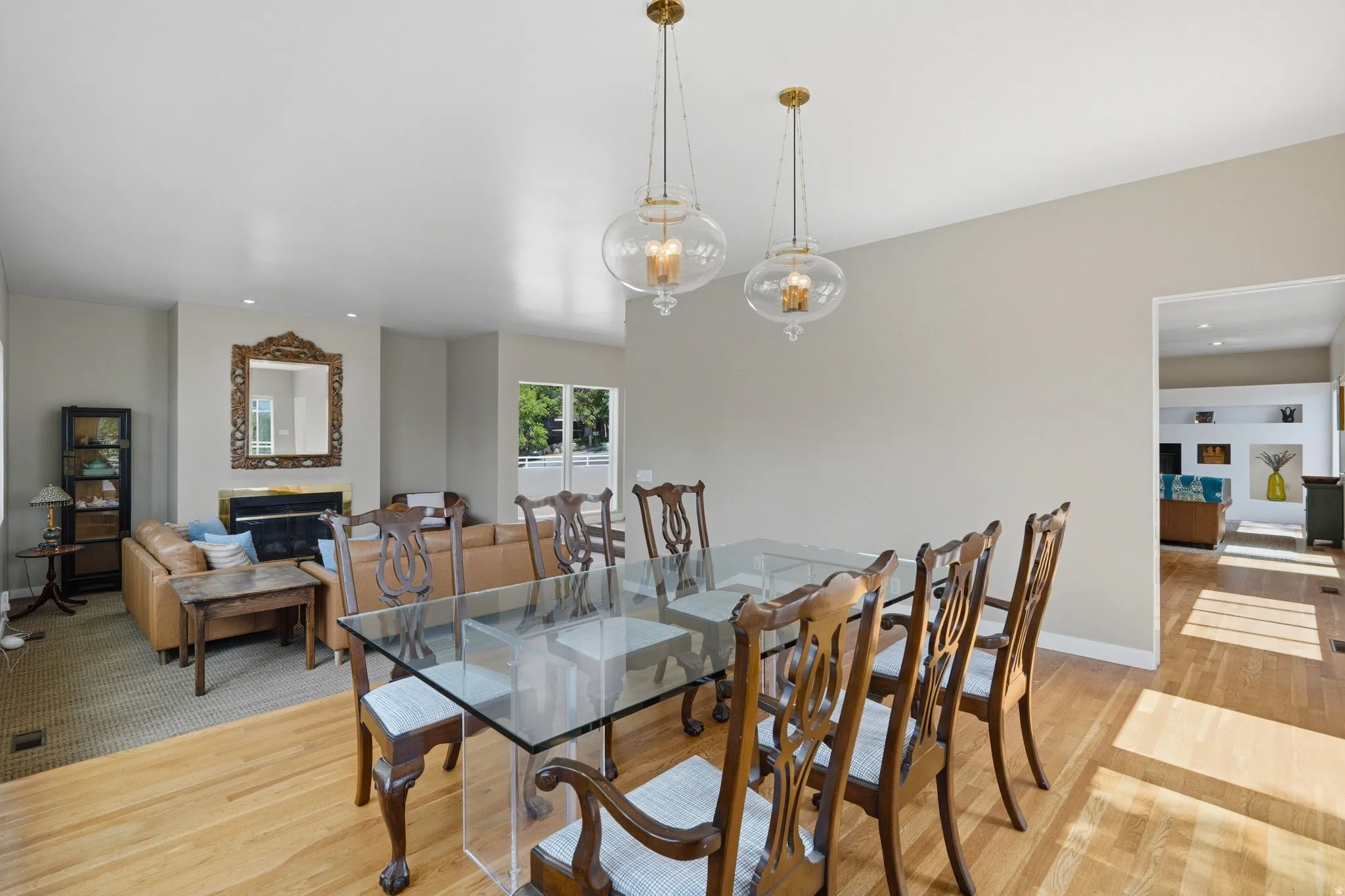 Hardwood flooring throughout, recessed lighting, and a fireplace with a decorative mantel and mirror